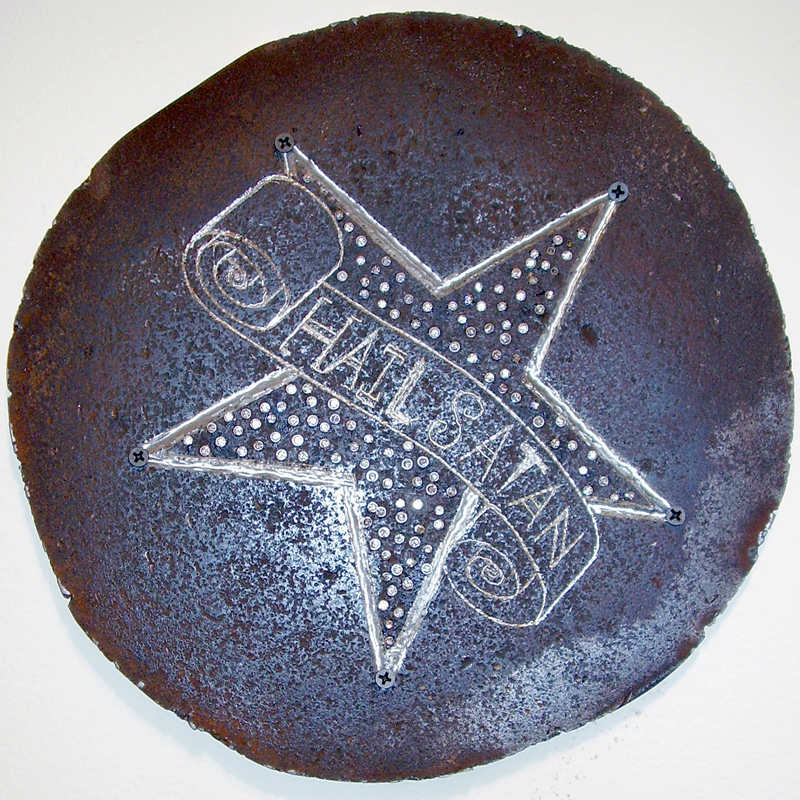 This is a thick steel sheet with a pentagram and a scroll etched into it. Oh, and the scroll reads Hail Satan.