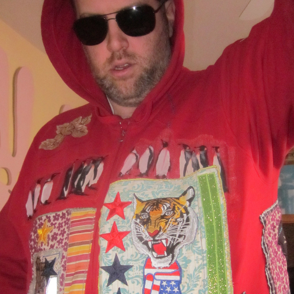 Semi close up of Chuck wearing the red penguin jacket.  He looks good and dumb at the same time.